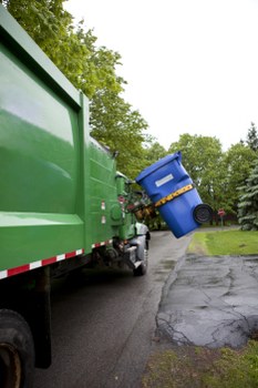 Staff wearing high-visibility PPE while loading a waste vehicle